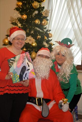 Zdjęcie przedstawia Mikołaja wręczającego prezenty