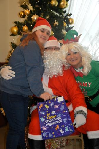 Zdjęcie przedstawia Mikołaja wręczającego prezenty