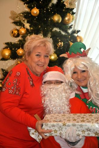 Zdjęcie przedstawia Mikołaja wręczającego prezenty