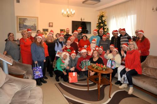 Zdjęcie przedstawia Mikołaja wręczającego prezenty