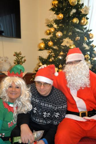 Zdjęcie przedstawia Mikołaja wręczającego prezenty